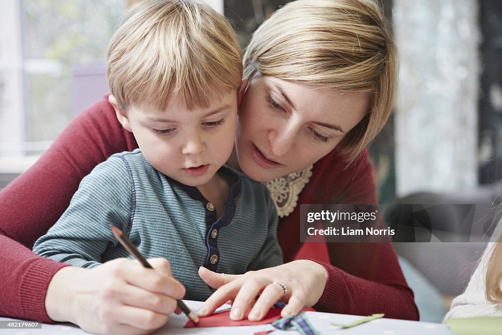 Mother and son drawing at kitchen table