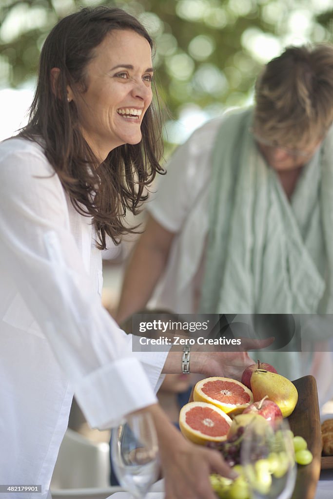 Woman serving platter of fruits