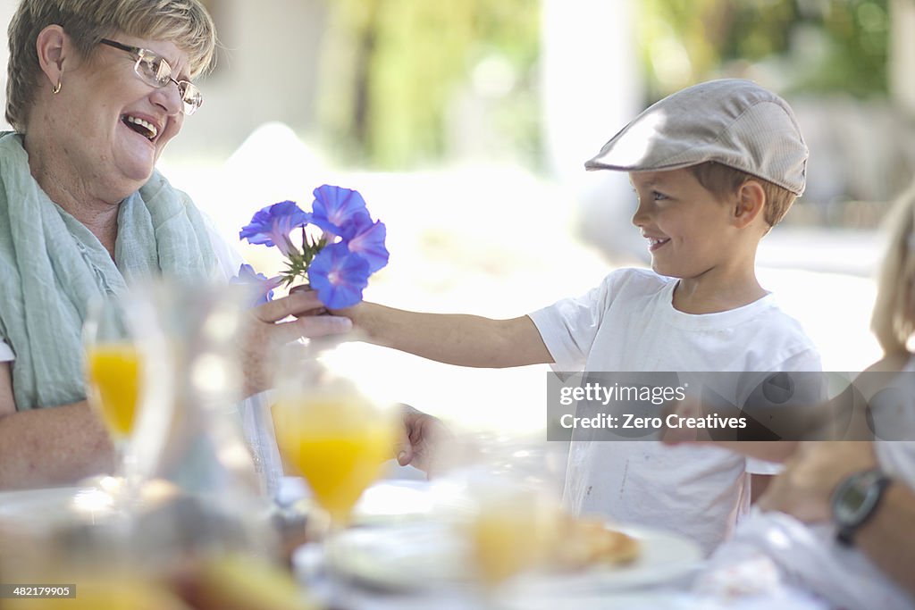 Boy giving flowers to grandmother