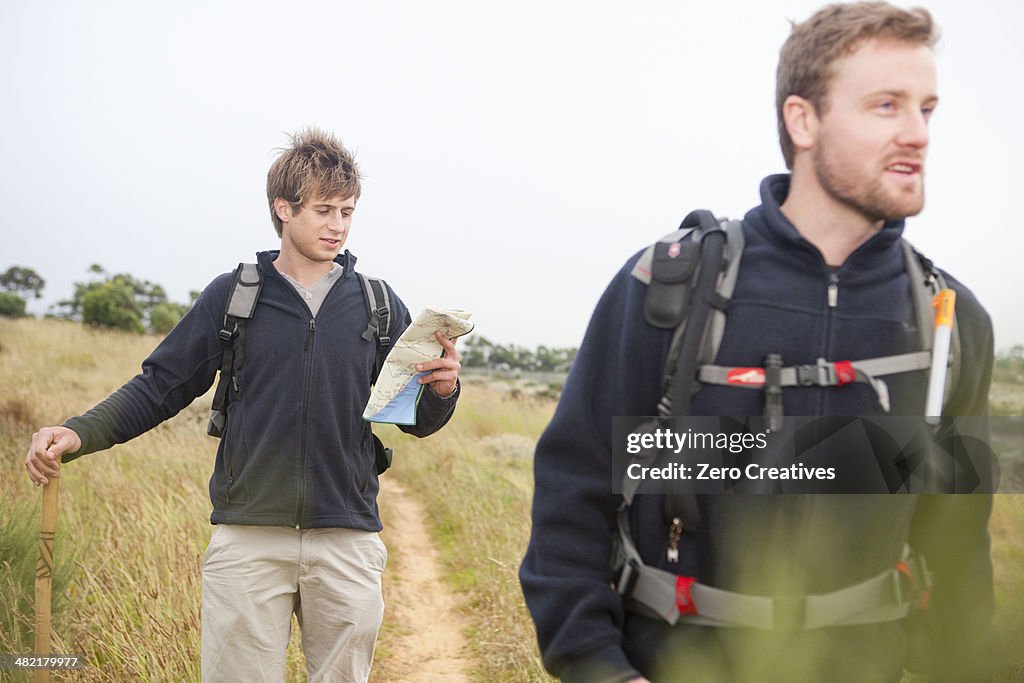 Two male hikers with backpacks and map