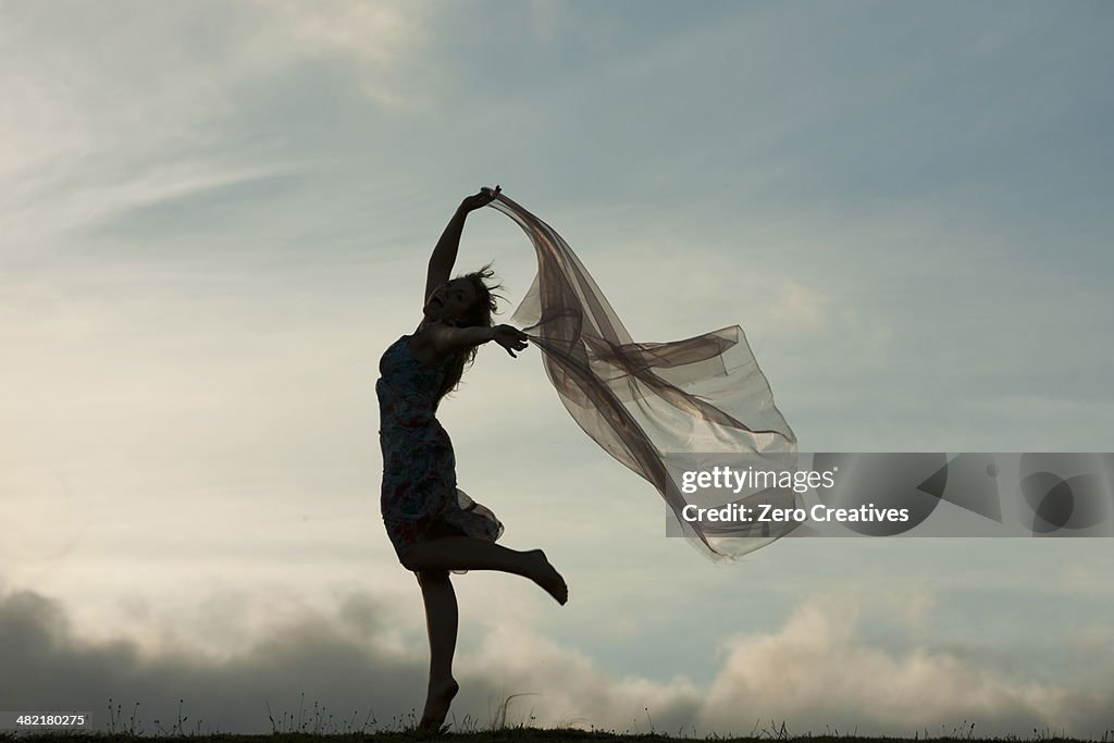 Woman dancing with sheer fabric over head