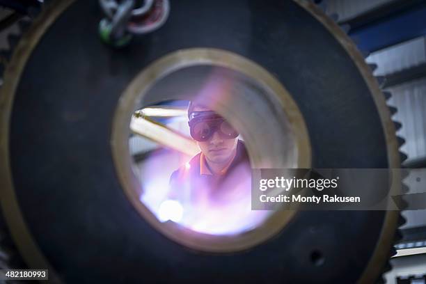 engineer heat treats industrial gear in factory, close up - engineer gearwheel factory stock pictures, royalty-free photos & images