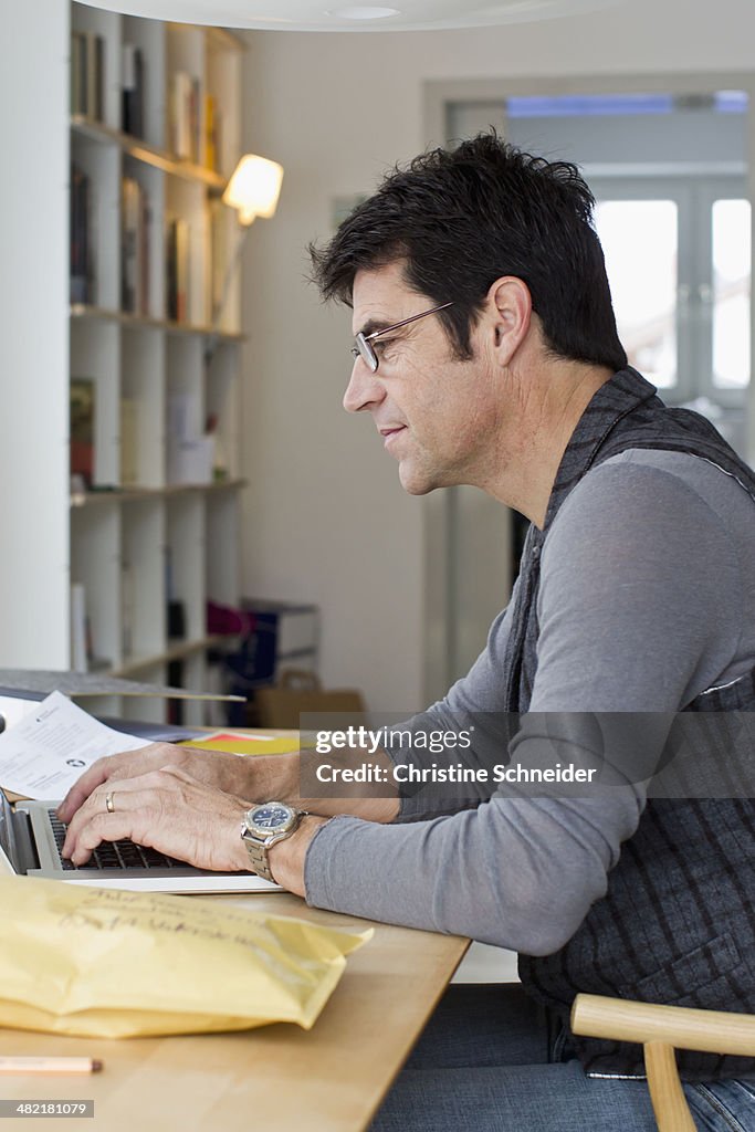 Mature businessman using laptop at home