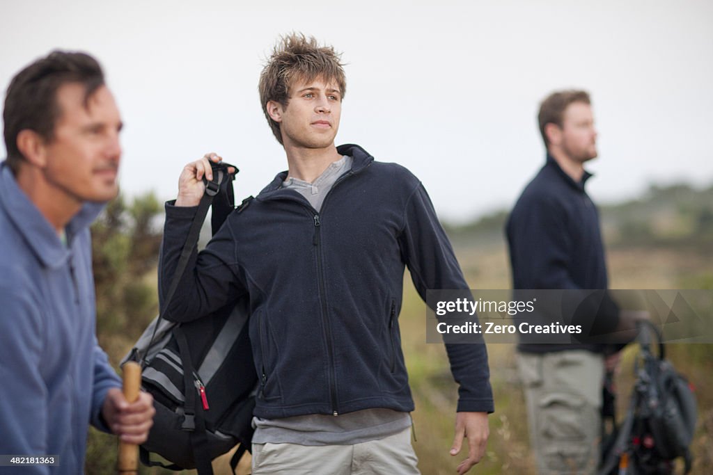 Three men hiking in rural landscape