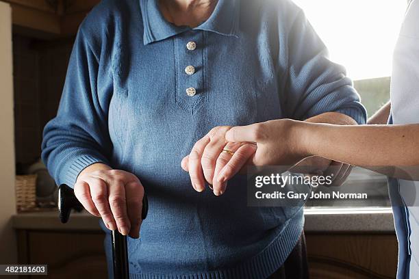 personal care assistant supporting senior woman to walk - norfolk east anglia - fotografias e filmes do acervo