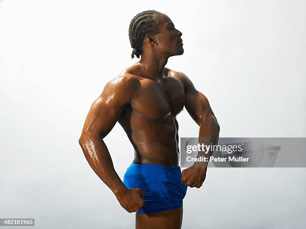 studio shot of male bodybuilder flexing abdominal muscles - black male bodybuilders foto e immagini stock