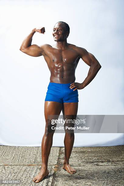 studio shot of male bodybuilder flexing muscles - black male bodybuilders foto e immagini stock
