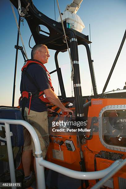 lifeboat crew steering boat at sea - 救命ボート ストックフォトと画像
