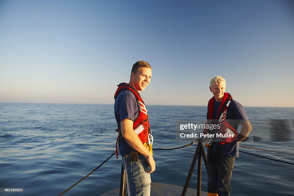 Portrait of two male lifeboat crew at sea