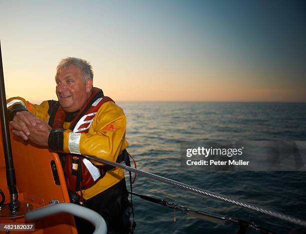 portrait of mature man crewing lifeboat at sea - 救命ボート ストックフォトと画像