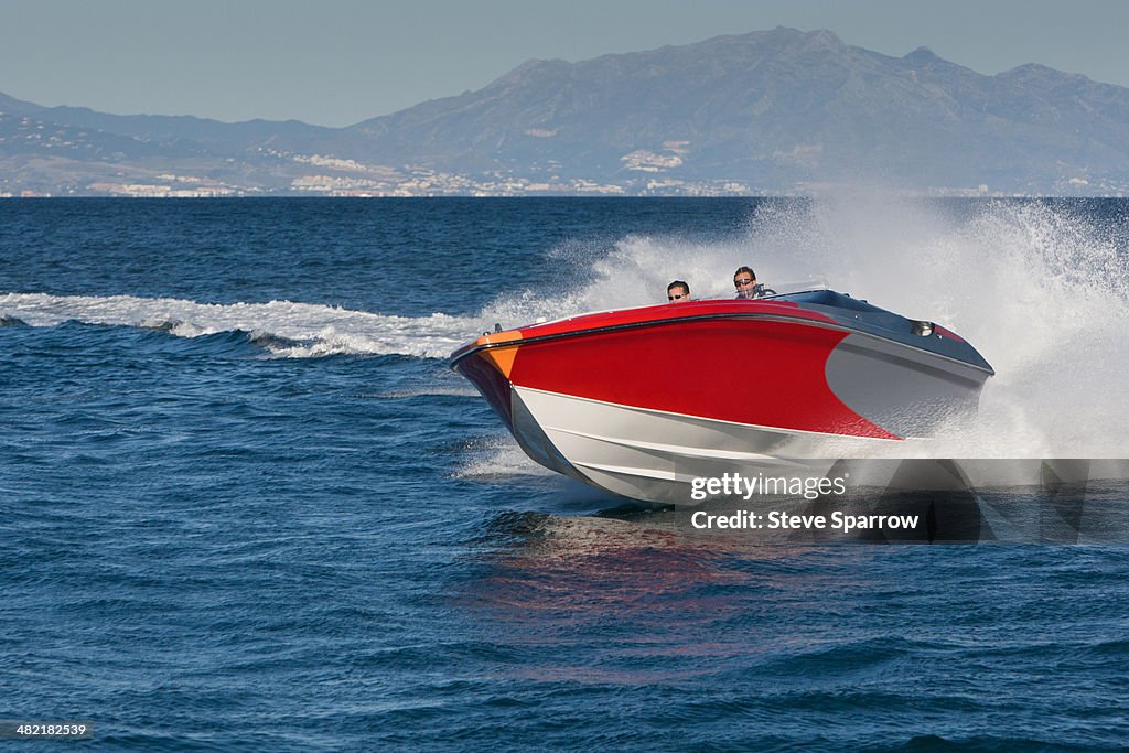 Two adult men having fun in speedboat, Sotogrande, Cadiz, Spain