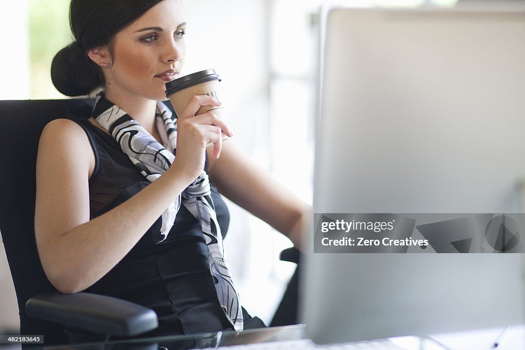 Young businesswoman taking a coffee break at desk