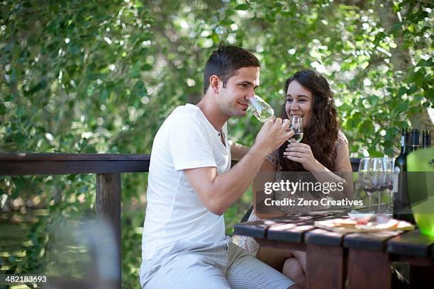 young couple tasting wine at vineyard bar - bar drink establishment stock pictures, royalty-free photos & images