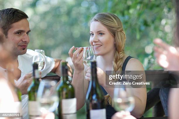 young friends tasting and smelling wine at vineyard bar - bar drink establishment stock pictures, royalty-free photos & images