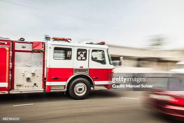 blurred motion shot of speeding fire engine - carro de bombeiro - fotografias e filmes do acervo