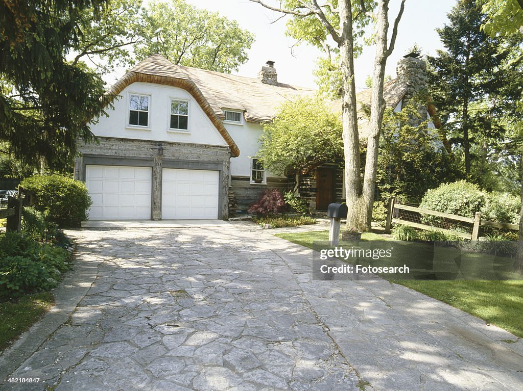 Front exterior of driveway leading to garage of traditional home