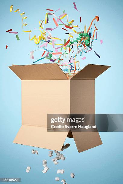 studio shot of cardboard box with streamers exploding out - exploded object stock pictures, royalty-free photos & images