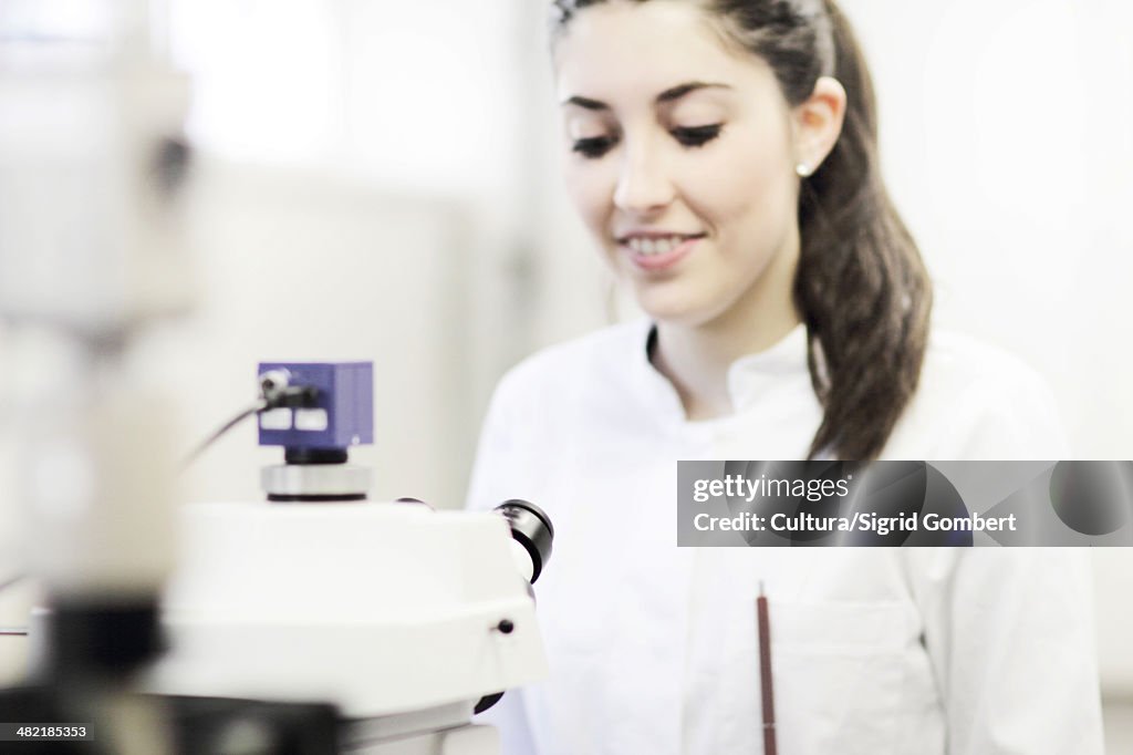 Scientist using microscope in lab