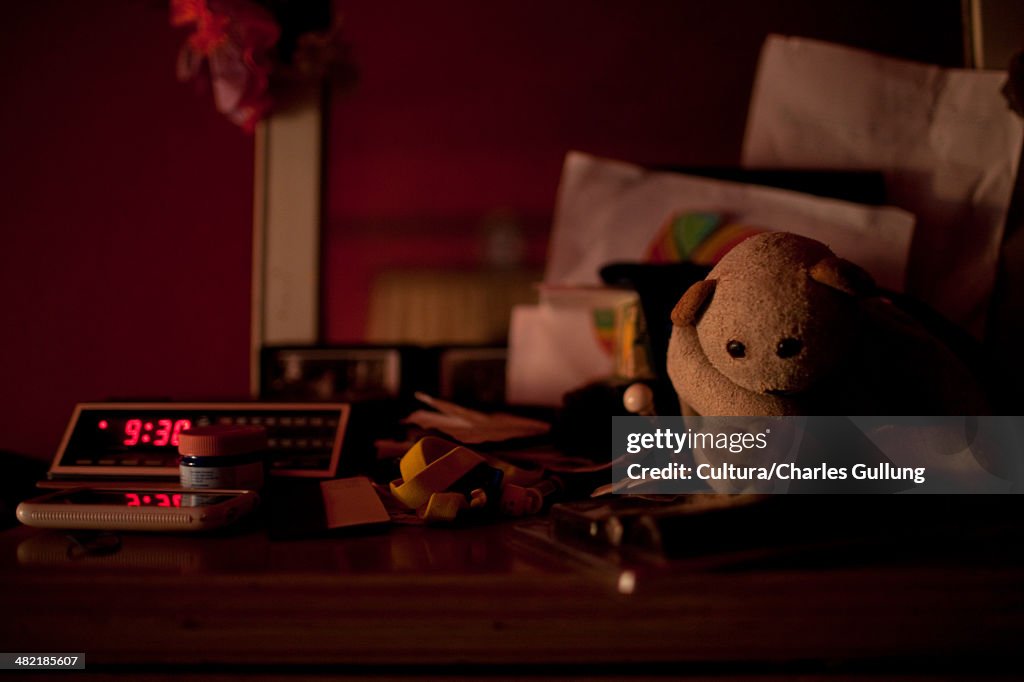 Digital alarm clock and toys on bedside table
