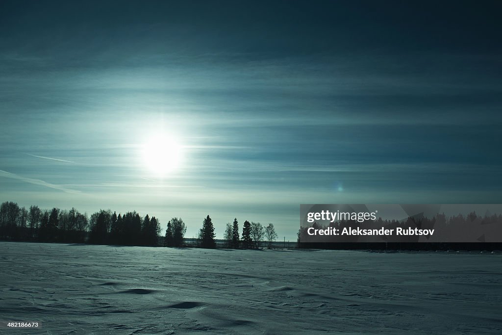 Field with snow in winter sunlight