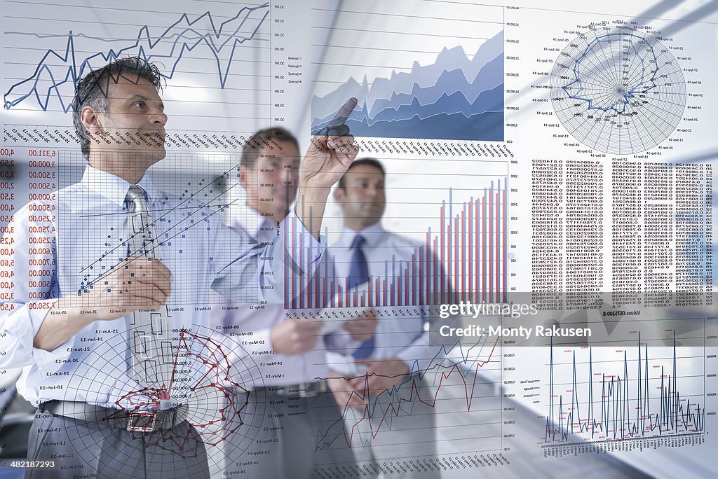 Businessmen discussing graphs and charts seen through screen