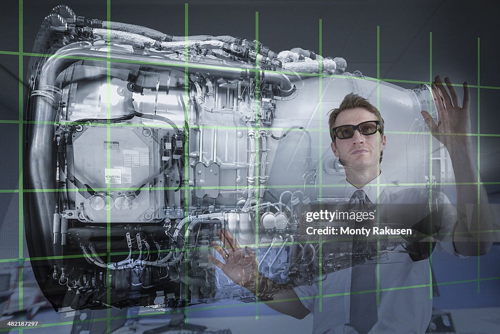 Engineer working with 3D display of Jet Engine, seen through interactive screen