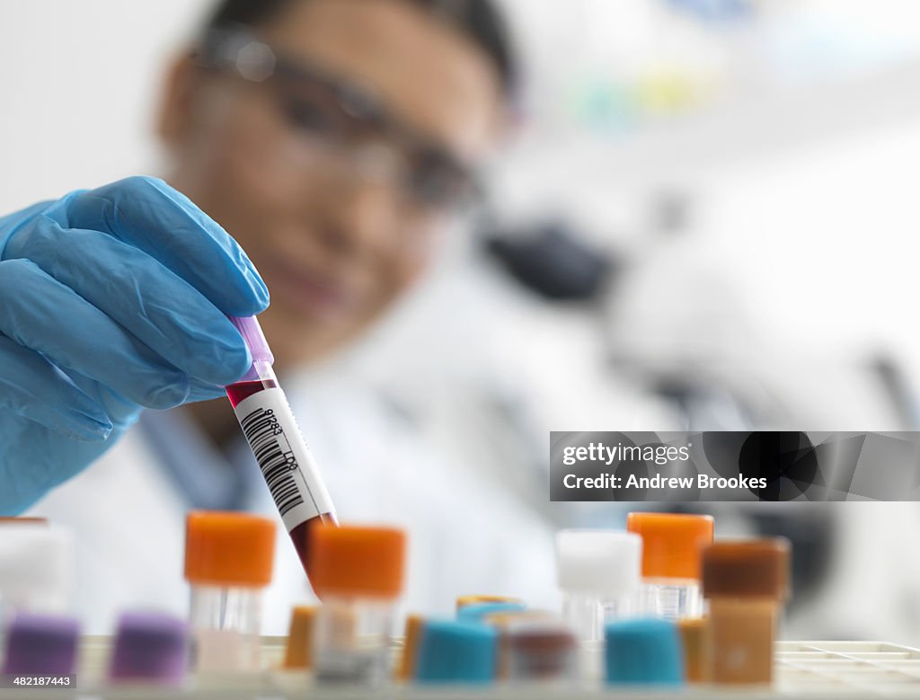 Female scientist about to view a human sample under a microscope
