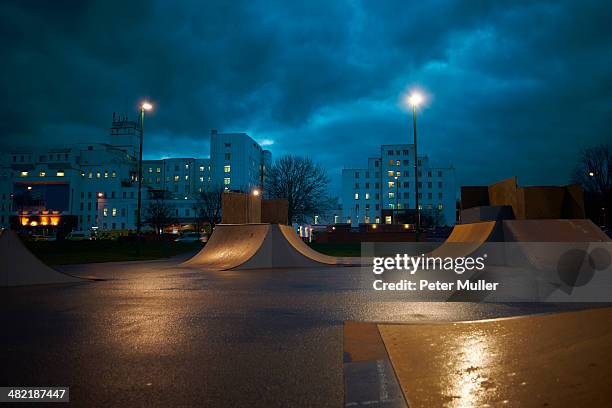 cityscape and skateboard park at night - skatepark foto e immagini stock