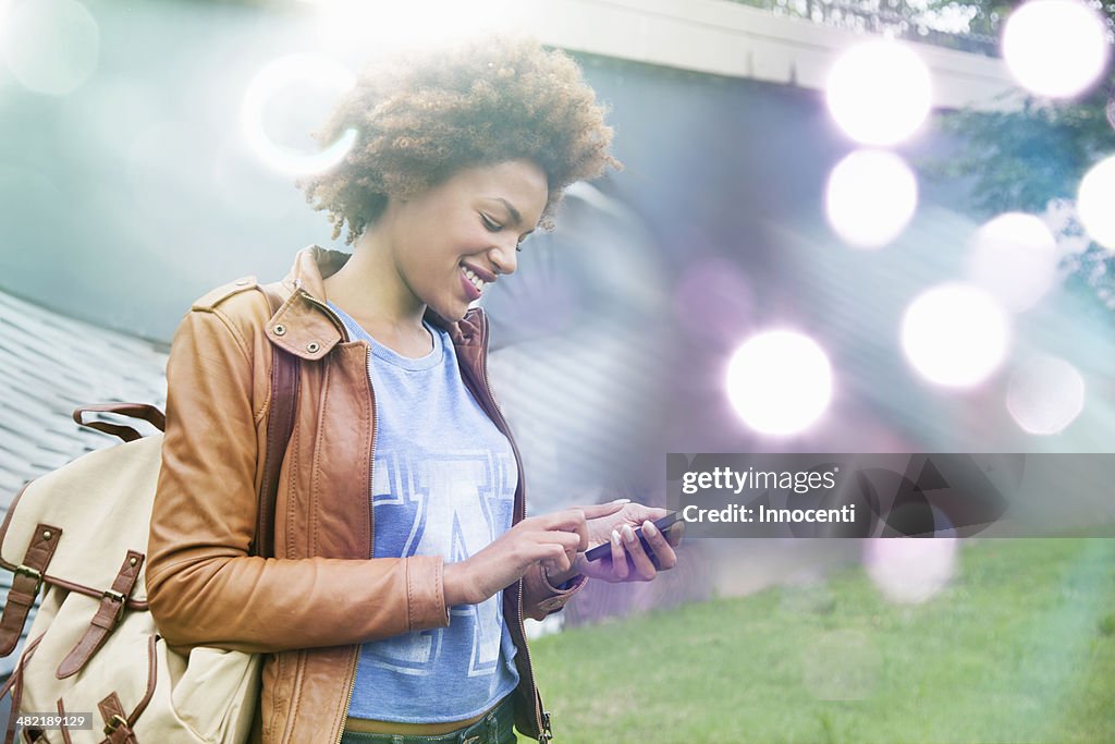 Glowing lights and young woman using smartphone