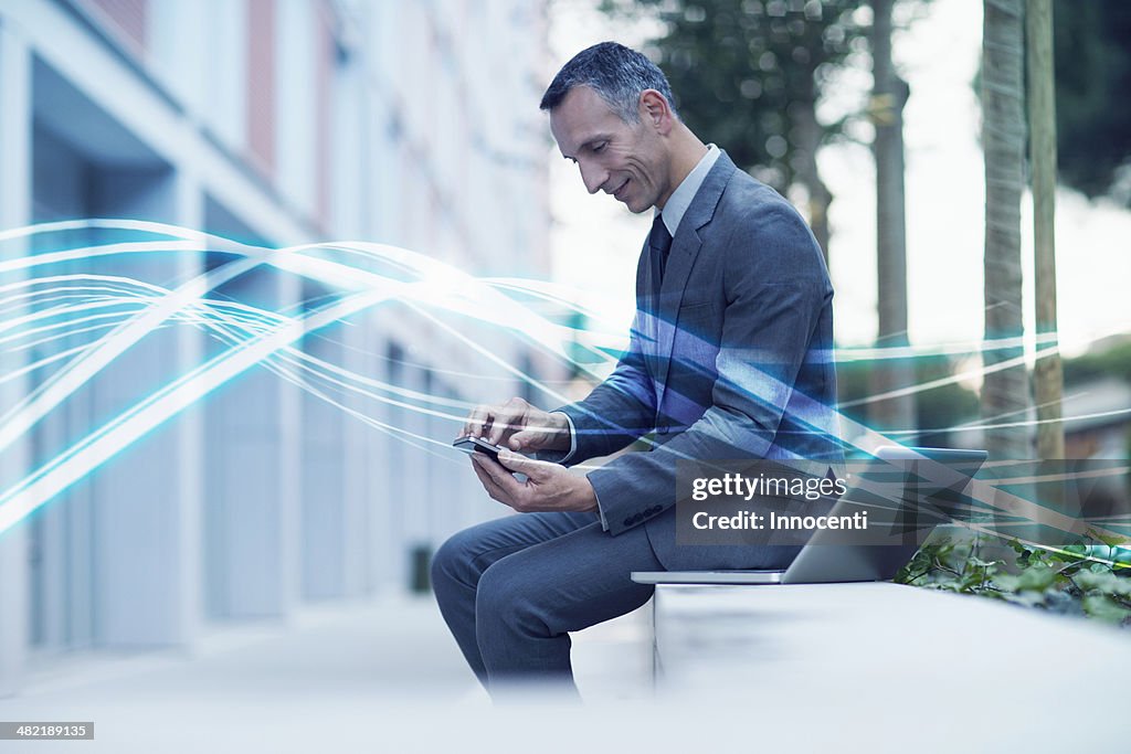 Waves of blue light and businessman texting on smartphone