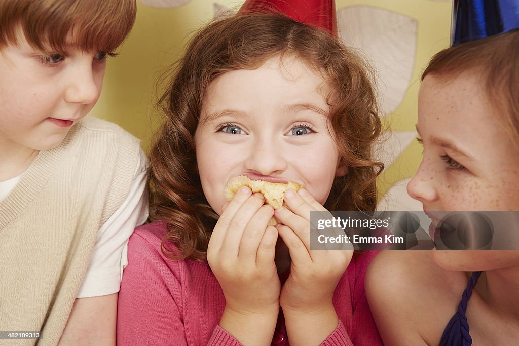 Girl eating party food, friends watching