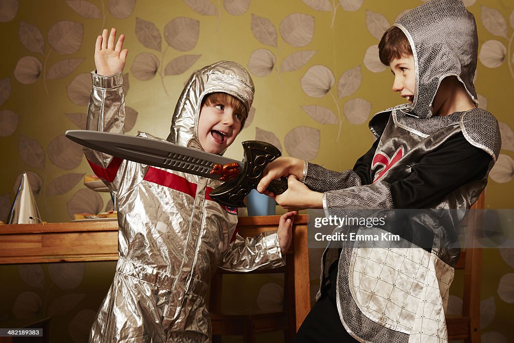 Two boys dressed as knights playing with toy sword