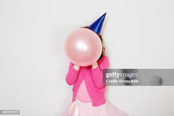 girl holding pink balloon in front of face - child balloon studio photos et images de collection