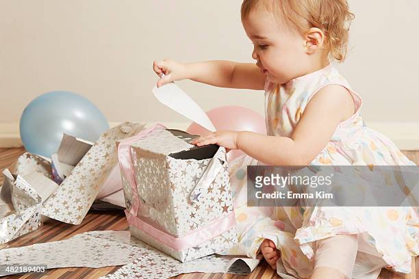 toddler girl opening birthday present - eerste verjaardag stockfoto's en -beelden