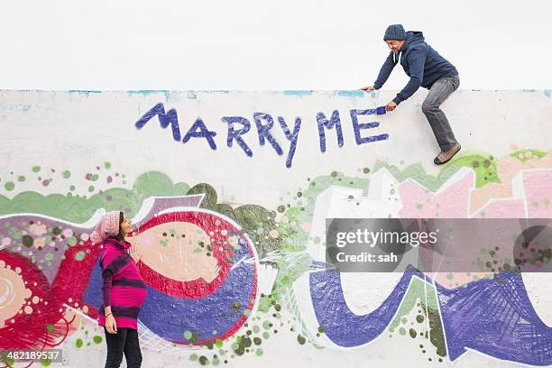 man proposing to pregnant woman - berlin graffiti stock-fotos und bilder