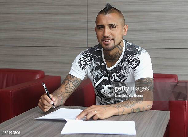 Chilean midfielder Arturo Vidal smiles as he signs his contract with FC Bayern Munich on July 28, 2015 in Munich, Germany.