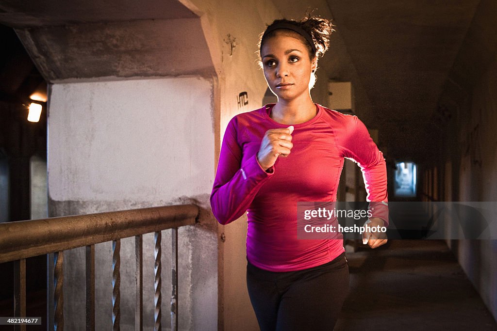 Young woman running on city bridge