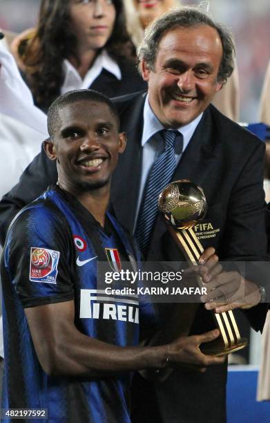 Inter Milan's Cameroonian striker Samuel Eto'o receives the golden ball trophy from UEFA president Michel Platini after his team won the 2010 FIFA...