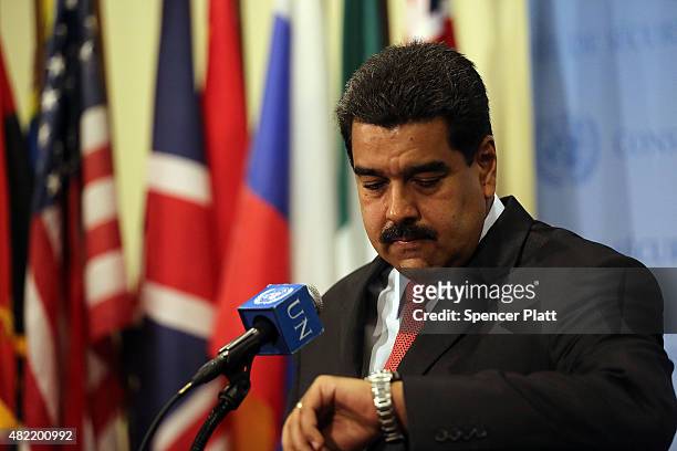 Venezuelan President Nicolas Maduro checks his watch as he speaks to the media following a meeting with UN chief Ban Ki-moon at the United Nations...