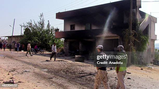 People gather around a burning wehicle after a US-led coalition forces airstrike targeting Al Nusra members in Kafer Hend village of Idlib, Syria on...