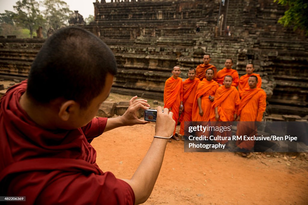 Monk taking photograph of monks, Phimeanakas Temple, Angkor Thom, Siem Reap, Cambodia