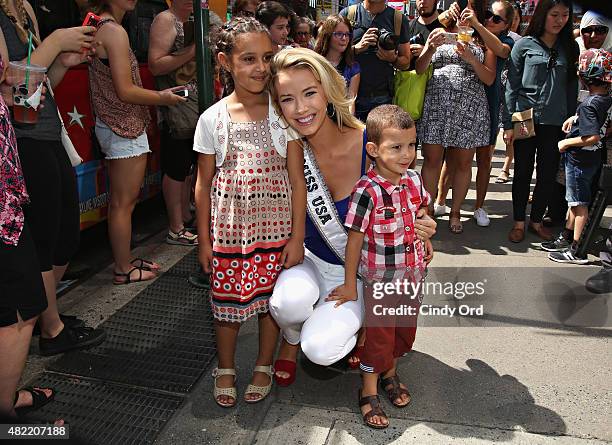 Miss USA 2015 Olivia Jordan poses with fans before taking a ride on the Gray Line CitySightseeing NYC bus on July 28, 2015 in New York City.