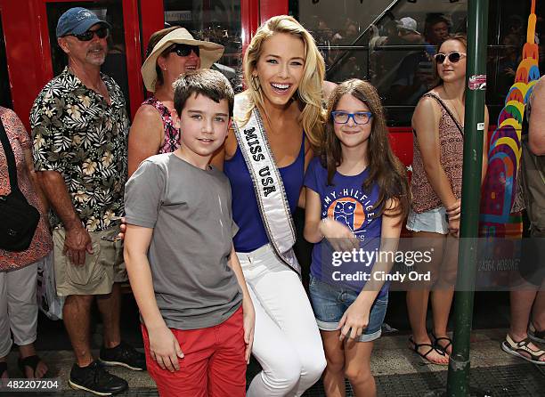 Miss USA 2015 Olivia Jordan poses with fans before taking a ride on the Gray Line CitySightseeing NYC bus on July 28, 2015 in New York City.