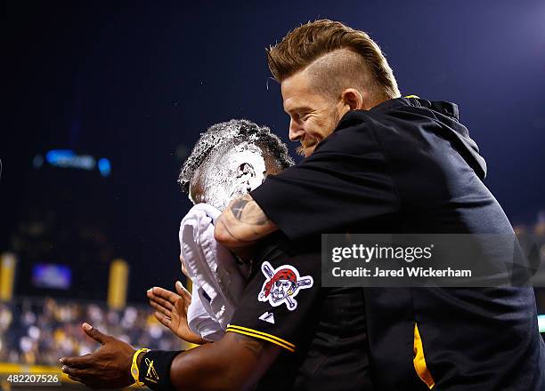 Andrew McCutchen of the Pittsburgh Pirates is smeared with whipped cream in the face by teammate A.J. Burnett after hitting the game-winning two run...