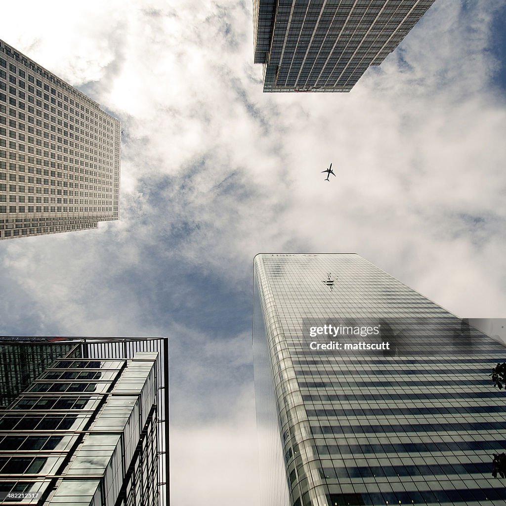 Plane flying past skyscrapers, Canada Square, London, England, UK