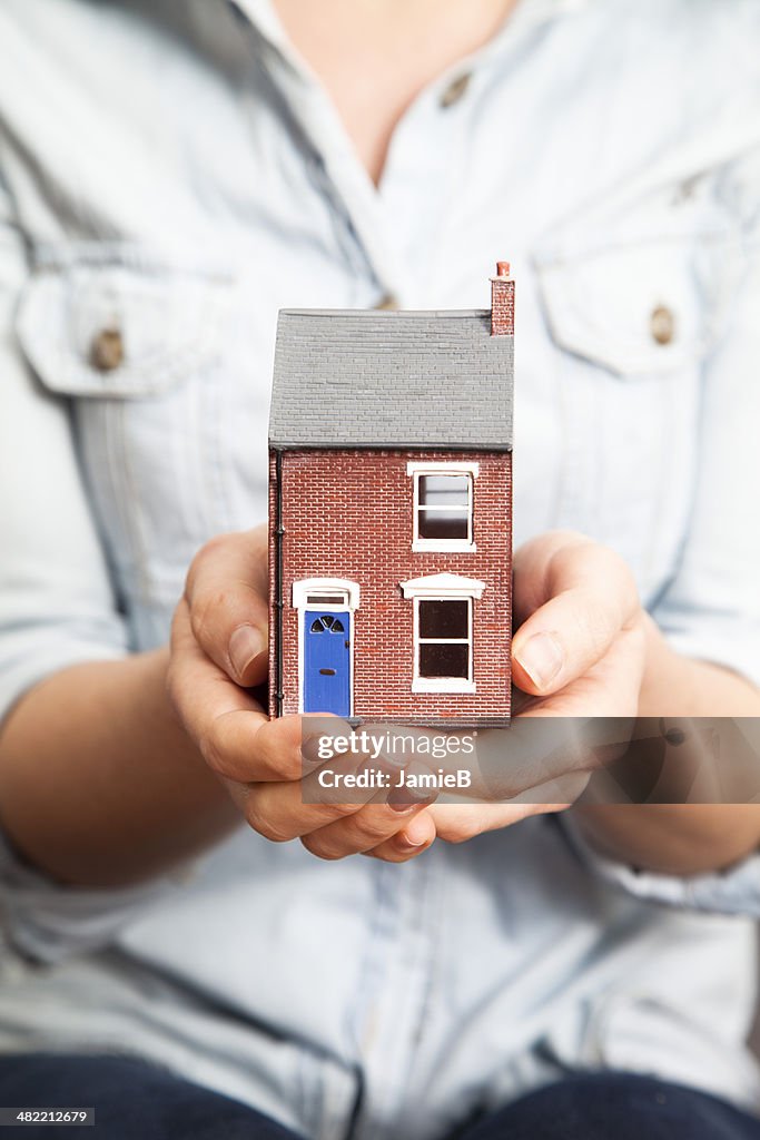 Woman's hands holding model house