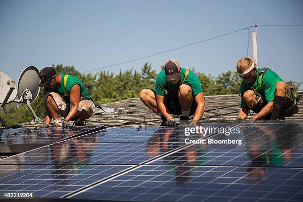 SolarCity Corp. Employees install solar panels on the roof of a home in Kendall Park, New Jersey, U.S., on Tuesday, July 28, 2015. SolarCity Corp. Is...