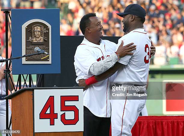 David Ortiz of the Boston Red Sox hugs Pedro Martinez, a former member of the Boston Red Sox, during a ceremony to retire Martinez's number 45 before...
