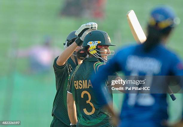 Bismah Maroof of Pakistan raises her bat after scoring a half century during the ICC Women's World Twenty20 7th/8th place ranking match between Sri...