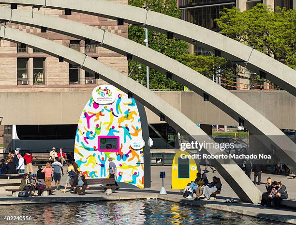 Zoom In view of Nathan Phillips Square pool corner with partial view of the concrete arches and people seated on benches next to a CISCO sponsored...